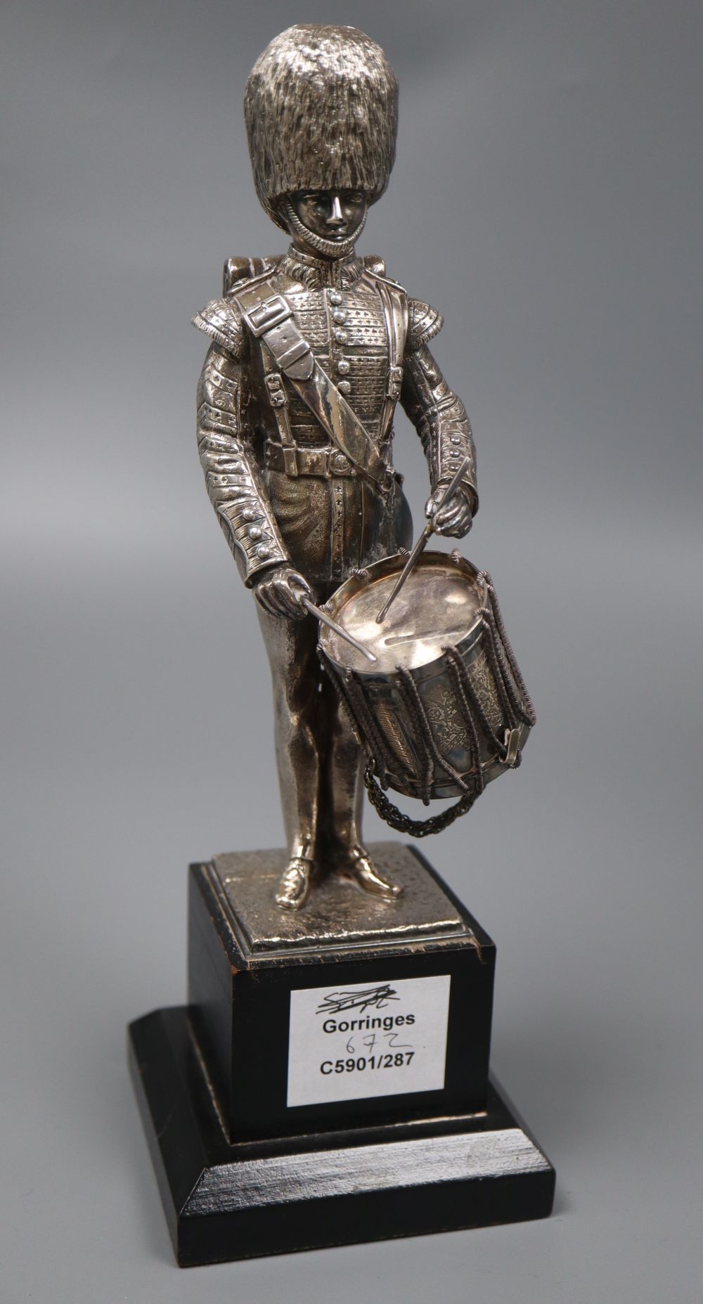 A modern silver (filled) model of a guardsman, with drum, Carrington & Co, London, 1988, on wooden plinth, overall 28.3cm.
